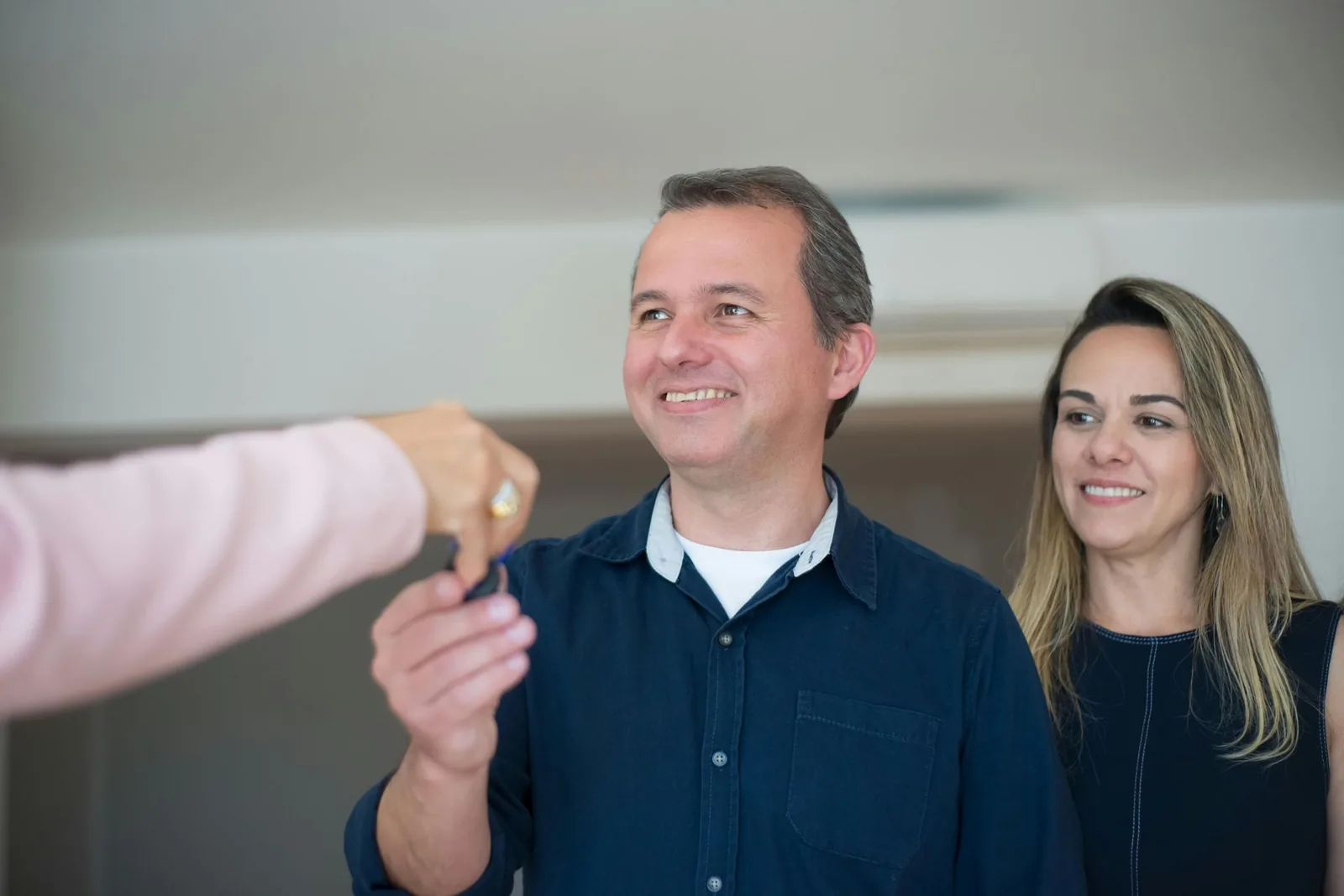 Smiling couple receiving the keys to their new home
